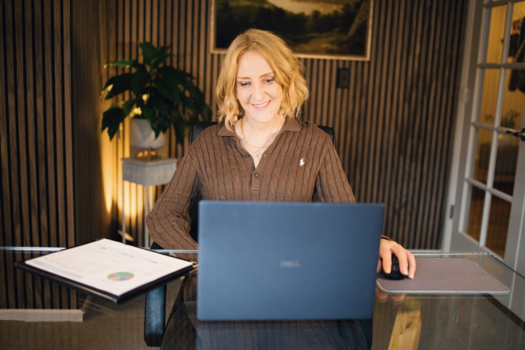 Julie Price smiling while working at her laptop